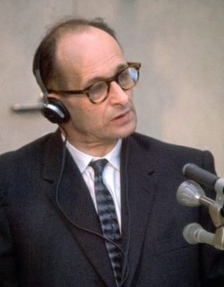 NAZI WAR CRIMINAL ADOLF EICHMANN SITTING IN A     GLASS CELL, AT HIS TRIAL AT BEIT HA'AM IN JERUSALEM.

צילום תקריב של הפושע הנאצי אדולף אייכמן בתוך "תא הזכוכית" המשוריין, במשפטו       שנערך בבית העם בירושלים.